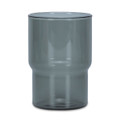 A drink tumbler in a transparent smokey grey colour with a distinctive curved design. Includes a logo.