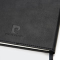 A black diary with a textured cover and a logo embossed on the front. It has a ribbon bookmark.