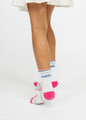 Custom branded kids socks featuring white fabric with pink accents and blue text, showcased from the back.