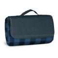 A folded picnic blanket in dark blue and navy check pattern, secured with a handle. It features a logo on the side.