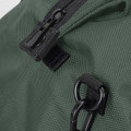 A close-up of a dark green duffle bag featuring a zipper and clip details, with a textured fabric finish.