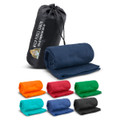 A fleece blanket in navy blue, rolled and packed in a black carry bag, with other blankets in various colours displayed beside it.