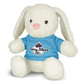 A soft, white plush toy rabbit wearing a blue shirt with a logo. It has long ears and a pink nose.