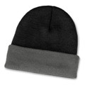 A two-toned beanie featuring black and grey hues with a folded cuff. It has a logo on the design.