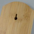 A drink bottle opener made of natural bamboo, featuring a keyhole for mounting on the wall.