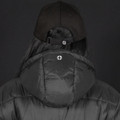 A black puffer jacket with a hood, worn by a person wearing a black cap, featuring a logo on the back.