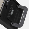 A black kitchen timer with a stand, featuring a metallic back and a small flip cover. It has a logo on the side.