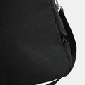 A black duffle bag with a subtle texture and an attachment point for a strap, featuring a small logo.