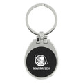A keychain with a silver metallic finish and a black textured circular centre featuring a logo.