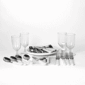 A picnic set features white-handled cutlery, glass tumblers, and serving platters on a white background.