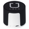 A wireless speaker in black and silver, featuring a logo. Compact design with a USB port.