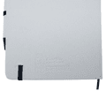 A white A5 notebook with a black elastic band and a black pen, featuring a subtle embossed logo.