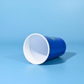 A drink cup with a blue exterior and white interior, featuring a logo, lying on a light blue background.