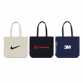 Three tote bags in various colours: a beige bag with a logo, a black bag with a logo, and a navy bag with a logo.