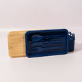 A navy blue lunch box with a bamboo lid and utensils, including a spoon and fork, included inside.