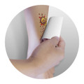 A hand applying a Temporary Tattoo Foil on an arm, featuring a colorful design.