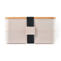 A Stax Eco Lunch Box in soft pink with a bamboo lid and a black elastic strap for secure closure.