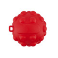 A red, round toy with a textured surface, featuring small raised bumps and a loop for attachment.