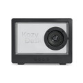 A black speaker with a prominent circular speaker and a transparent front, featuring branding and control buttons at the bottom.