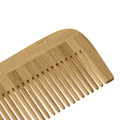 A bamboo comb in a light brown shade with a smooth finish and wide teeth, featuring a small logo.
