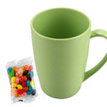 A green bamboo mug next to a pack of multicoloured jelly beans. The mug features a handle and a smooth finish.