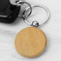 A wooden round key ring in natural wood finish attached to a silver metal keychain.