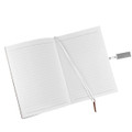 An open notebook with lined pages, featuring a ribbon bookmark and a silver pen. The notebook has a logo on the cover.