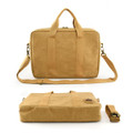 A tan satchel with dual handles, a detachable strap, and a logo, featuring a smooth, textured surface.