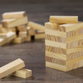 A set of small wooden blocks in light wood tones, stacked to form a tower, with additional blocks scattered nearby.