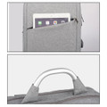 A grey laptop backpack with a tablet in the front pocket and a handle at the top. It features a logo.