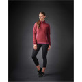 A woman wearing a burgundy women's fleece jumper with a 1/4 zip and black leggings, featuring a branding logo.