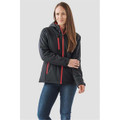 A woman wearing a black insulated softshell jacket with red accents and a hood, standing against a neutral background.