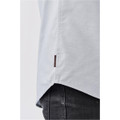 A light grey button-up shirt with a side tag detail, shown from a close-up angle.