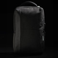 A sleek black backpack with a textured finish and a subtle logo, featuring zippered compartments and a sturdy handle.
