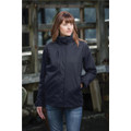 A woman wearing a black women's parka jacket, standing outdoors near a wooden structure.