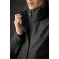 A close-up of a woman's Montauk System Jacket in dark grey, featuring a zipped collar and button details.