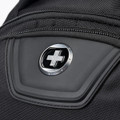 A close-up of a black backpack featuring a logo and a zipped pocket. The material appears durable and textured.