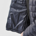 A navy blue women's puffer jacket with an unzipped interior pocket and quilted design. Features a logo on the sleeve.