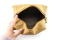 A kraft paper cosmetic bag in a light brown hue, featuring an unzipped opening with a fabric interior.