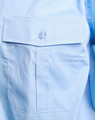 A light blue button-up shirt featuring a chest pocket and a button closure. The shirt has a subtle sheen.