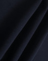 A close-up of dark navy polar fleece fabric showing soft, smooth texture folds. It features a branding logo.