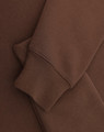 A brown 1/2 zip collar fleecy sweat featuring a smooth fabric and a cuffed sleeve. Includes branding.
