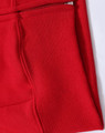 A close-up of a red fleecy hoodie featuring a full-zip and zippered pocket. The fabric appears soft and textured.