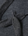 A close-up of a dark grey fleece hoodie showing the texture of the fabric and a knitted drawstring.