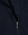 A navy softshell high-tech jacket featuring a zippered front and a fleece lining. The jacket includes a logo.