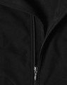 A black softshell vest featuring a zip closure and a textured interior. The vest includes a logo.
