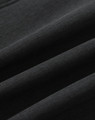 A close-up of a black softshell fabric with a smooth texture, featuring folds and creases.