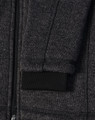 A dark heather grey fleece jacket with a black ribbed cuff and zipper detail. It also features a logo.