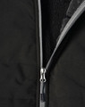 A black quilted jacket featuring a zippered closure and a soft interior lining. It has a logo on the surface.
