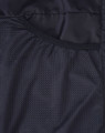 A black textured fabric featuring mesh detailing, part of a men's sustainable insulated puffer jacket.